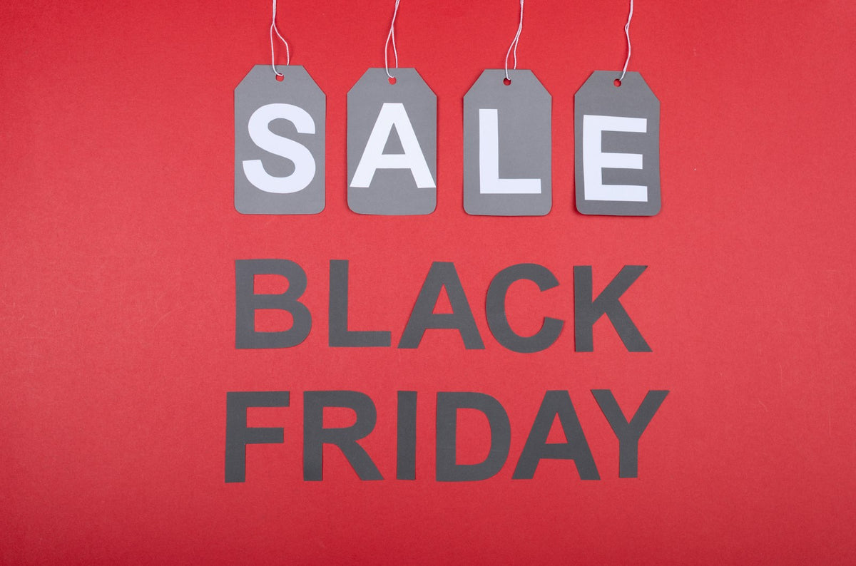 Étiquettes SALE et inscription Black Friday sur fond rouge