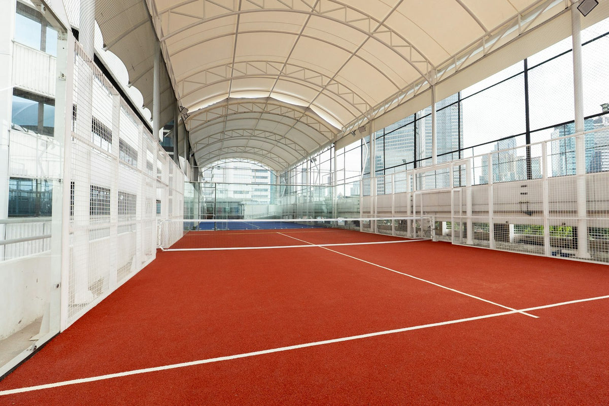 Terrain de padel couvert sous une toiture, entre indoor et outdoor